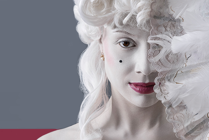 Imagen de actriz con maquillaje característico de la época del siglo 18 en la que surgió el compositor Amadeus Mozart.